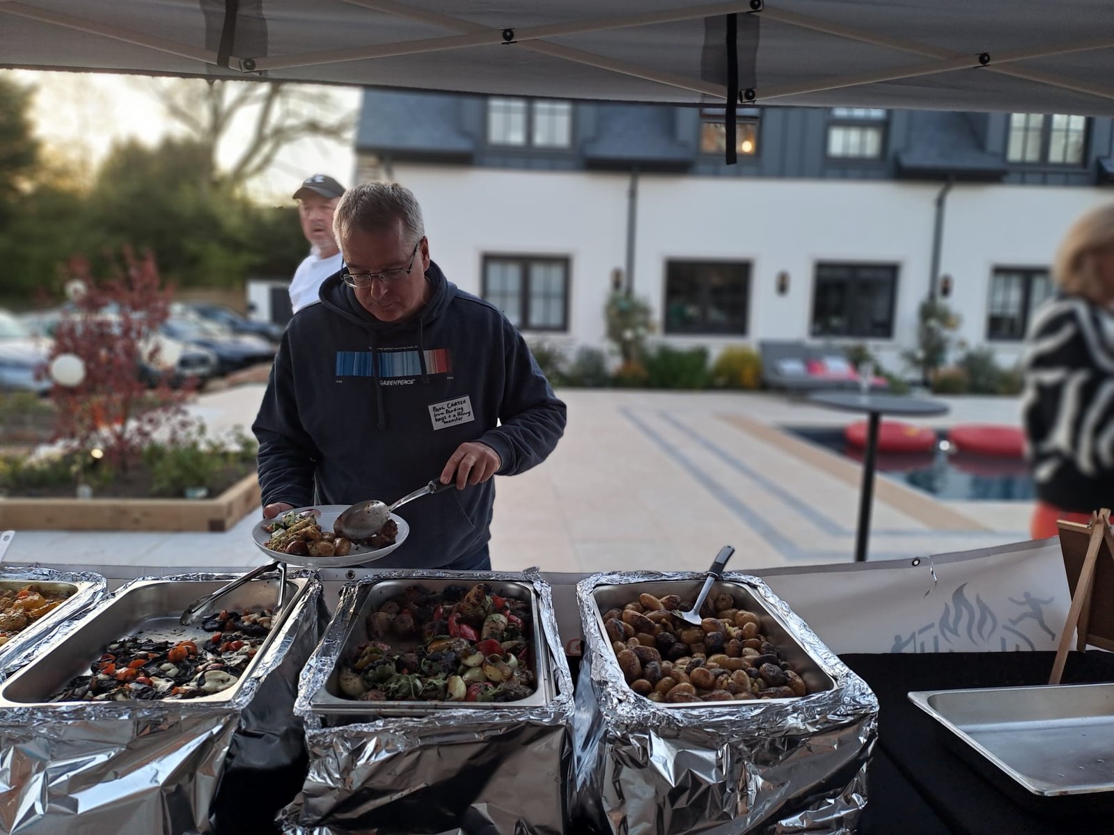 A guest choosing food at a Grill Seekers garden party buffet